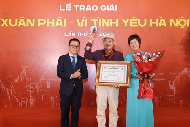 Đồng chí Lê Quốc Minh, Ủy viên Trung ương Đảng, Tổng Biên tập Báo Nhân Dân, Phó Trưởng ban Tuyên giáo và Dân vận Trung ương, Chủ tịch Hội Nhà báo Việt Nam cùng lãnh đạo Thông tấn xã Việt Nam trao Giải thưởng Lớn - Vì tình yêu Hà Nội được trao cho nhạc sĩ Trần Tiến.
