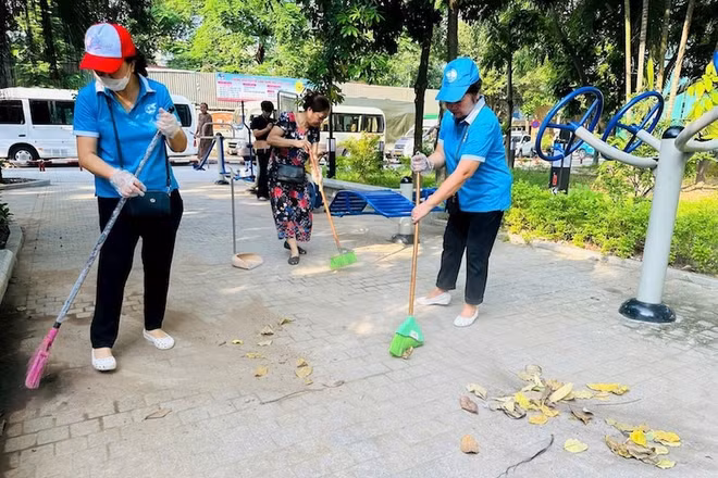 Người dân tham gia dọn dẹp vườn hoa Trần Quang Diệu sau một thời gian bị xuống cấp. 