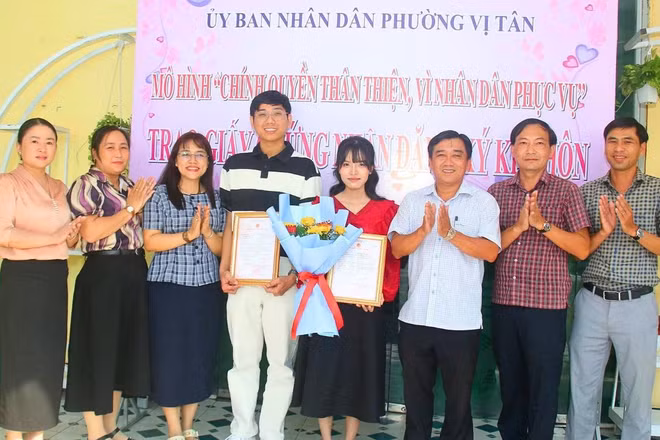 Lãnh đạo Ủy ban nhân dân phường và Trung tâm Phục vụ hành chính công phường Vị Tân trao giấy chứng nhận kết hôn và tặng hoa chúc mừng cặp đôi.