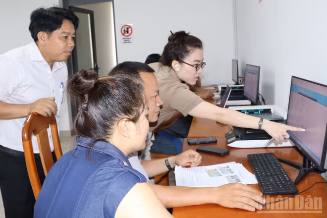 Cán bộ Trung tâm phục vụ hành chính công phường Long Thành hướng dẫn người dân nộp hồ sơ trực tuyến theo phương châm "cầm tay, chỉ việc".