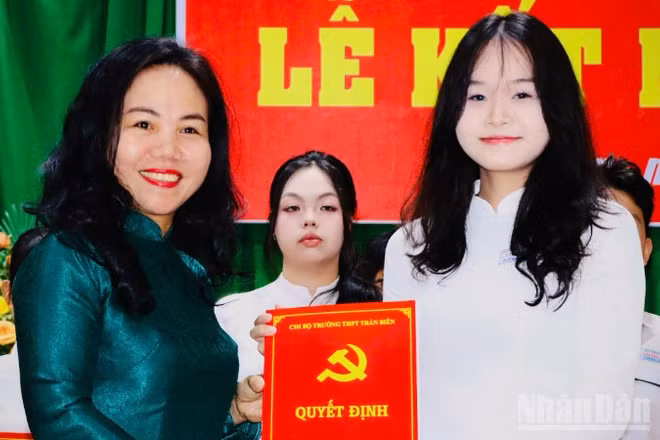 Đồng chí Phạm Thị Thanh Hà, Bí thư Chi bộ, Hiệu trưởng Trường trung học phổ thông Trấn Biên trao quyết định kết nạp đảng viên cho học sinh.