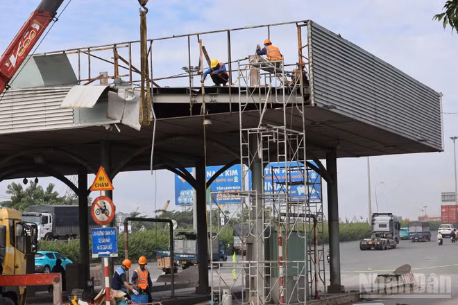 Đơn vị thi công tiến hành tháo dỡ trạm thu phí ngưng hoạt động ở khu vực cầu Đồng Nai trong ngày 11/8. (Ảnh: THIÊN VƯƠNG)