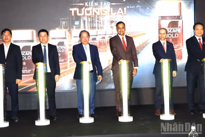 Các đại biểu thực hiện nghi thức vận hành dây chuyền đóng gói cà-phê hòa tan trong hũ thủy tinh tại Nhà máy Nestlé Trị An. (Ảnh: THIÊN VƯƠNG)