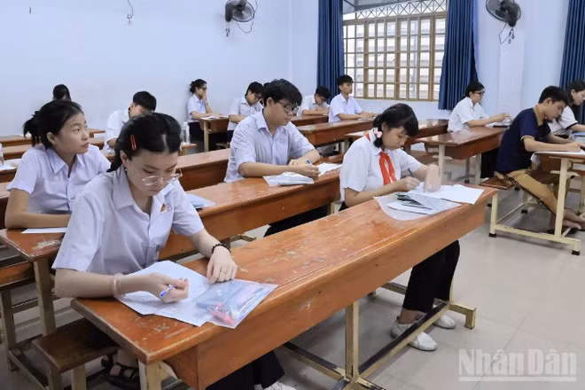 Thí sinh điền thông tin vào giấy thi, chuẩn bị bước vào môn thi đầu tiên tại điểm thi Trường trung học phổ thông Ngô Quyền.