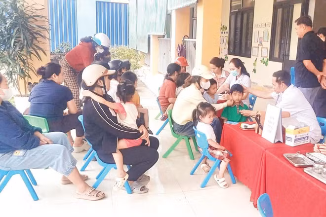 Người dân đưa trẻ đến tiêm chủng vắc-xin tại Trạm Y tế xã Hương Phố, tỉnh Hà Tĩnh.