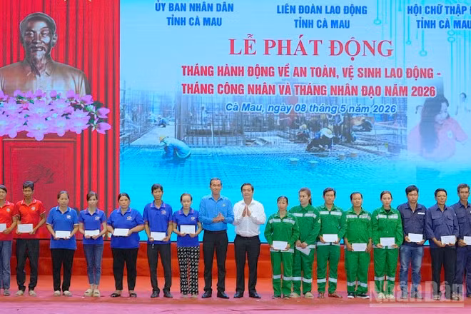 Đại diện lãnh đạo tỉnh Cà Mau và Liên đoàn Lao động tỉnh (đứng giữa) trao quà tặng cho công nhân, công đoàn viên, người lao động tại lễ phát động.
