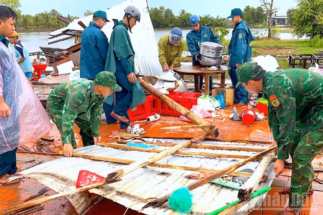 Cán bộ, chiến sĩ Đồn biên phòng Khánh Tiến chung tay cùng địa phương giúp người dân khắc phục hậu quả sau thiên tai.