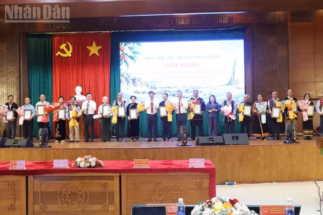 Lãnh đạo tỉnh Đắk Lắk trao giấy chứng nhận và tặng hoa chúc mừng các già làng, người có uy tín tiêu biểu. (Ảnh: CÔNG LÝ)