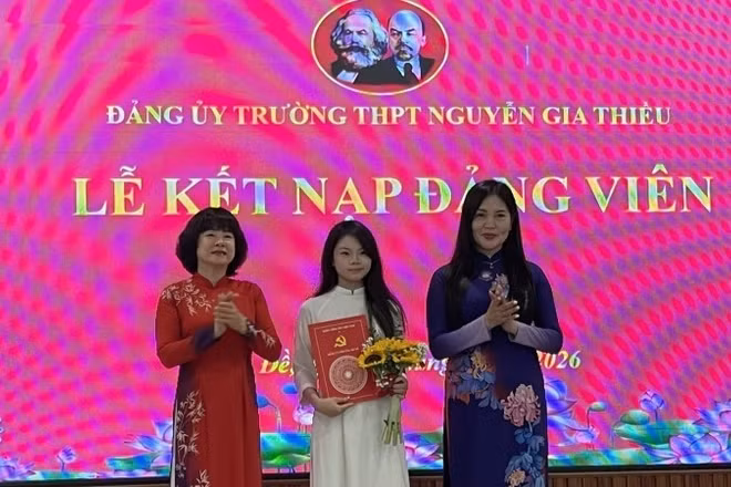 Bí thư Đảng ủy, Chủ tịch Hội đồng nhân dân phường Bồ Đề Vũ Thị Thành (người đứng bên trái) trao quyết định kết nạp Đảng cho học sinh trường Trung học phổ thông Nguyễn Gia Thiều.