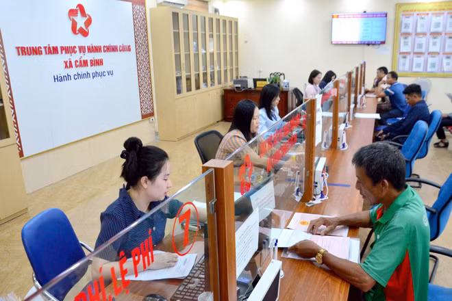 Cán bộ Trung tâm Phục vụ hành chính công xã Cẩm Bình, tỉnh Hà Tĩnh hướng dẫn người dân triển khai thủ tục hành chính. (Ảnh: MINH CHÍNH)