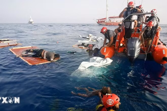 Tàu của Lực lượng bảo vệ bờ biển Italia vớt thi thể người di cư trôi dạt trên Địa Trung Hải. (Ảnh: AFP/TTXVN)