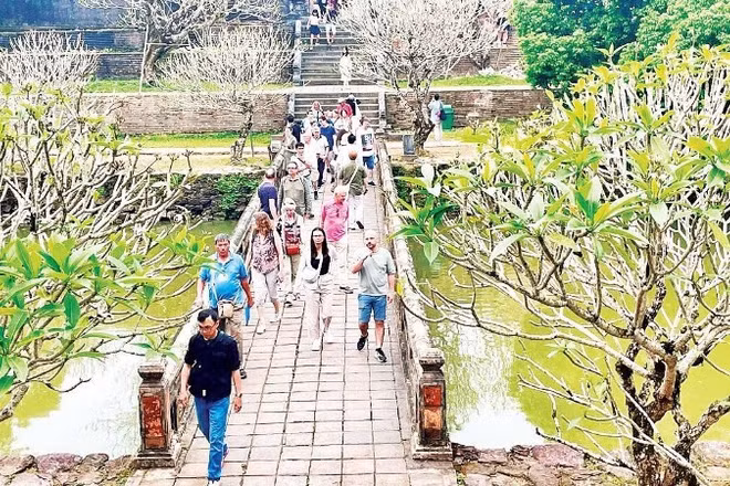 Du khách quốc tế tham quan một điểm di tích tại Huế.