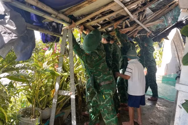 Cán bộ, chiến sĩ Đồn Biên phòng Xuân Đài giúp dân khắc phục hậu quả sau bão số 13.