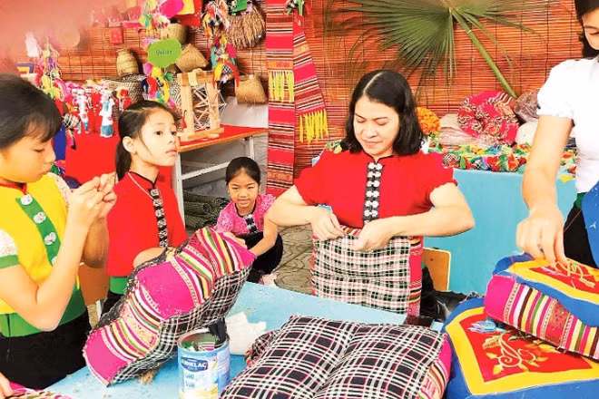 Hướng dẫn trẻ cách hoàn thiện đệm thổ cẩm tại phường Nghĩa Lộ.