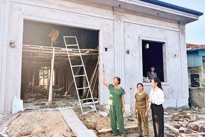 Ngôi nhà khang trang, kiên cố của bà Trần Thị Minh (áo xanh) ở thôn Thạch Mỹ, xã Mai Phụ đang dần được hoàn thiện. 