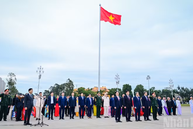 Các đại biểu dự lễ báo công thực hiện nghi thức chào cờ.