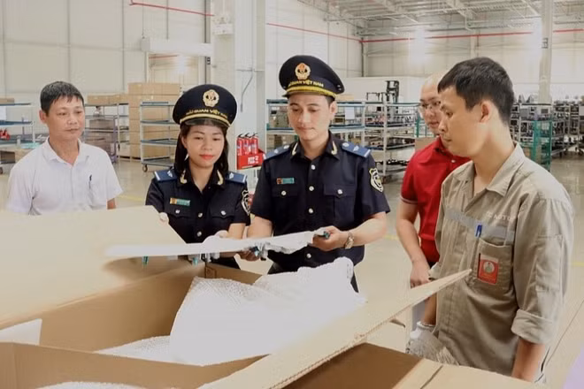 Công chức hải quan kiểm tra Danh mục hàng hóa miễn thuế. (Ảnh: Bùi Nụ)