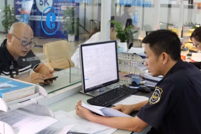 Cán bộ hải quan hướng dẫn, giải quyết thủ tục cho doanh nghiệp tại khu vực làm thủ tục.