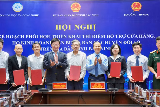 Trao Thỏa thuận hợp tác triển khai thí điểm hỗ trợ cửa hàng, hộ kinh doanh bán buôn, bán lẻ chuyển đổi số trên địa bàn tỉnh Bắc Ninh. (Ảnh: Bộ Khoa học và Công nghệ)