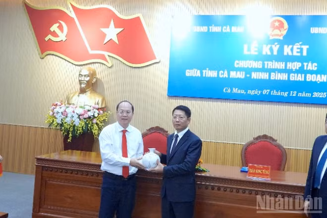 Bí thư Tỉnh ủy Cà Mau Nguyễn Hồ Hải (bìa trái) tặng quà lưu niệm cho đại diện tỉnh Ninh Bình tại lễ ký kết.