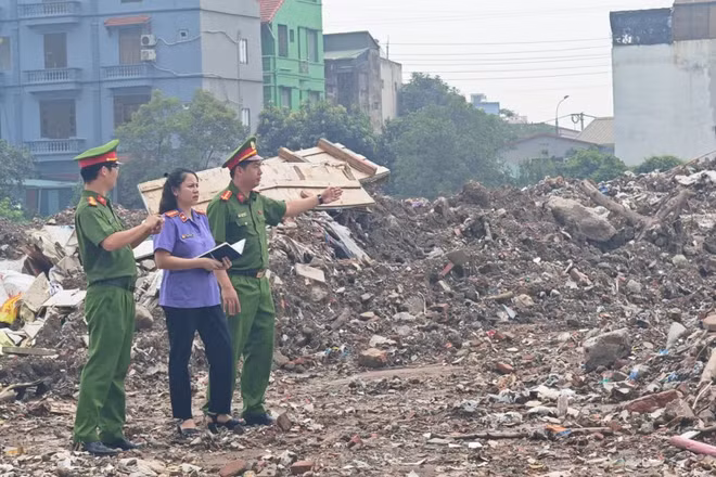 Lực lượng chức năng tại hiện trường, xác định diện tích và khối lượng chất thải xây dựng bị đổ trái phép. (Ảnh: Công an Hà Nội)