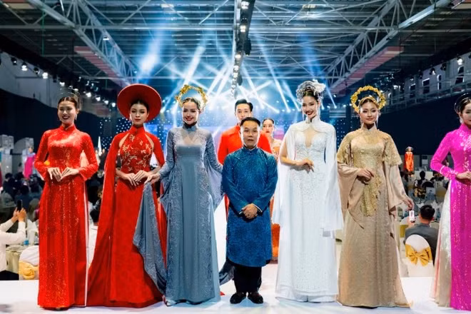 Nhà thiết kế Nguyễn Việt Hùng cùng các người mẫu trình diễn bộ sưu tập áo dài truyền thống của phụ nữ Việt Nam được thiết kế trên chất liệu vải Thái Tuấn.