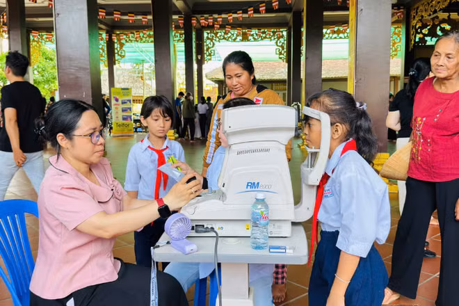 Bác sĩ khám mắt cho học sinh trong chương trình "Ngày thứ Bảy vì dân".