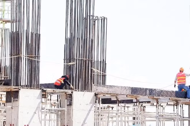 Công nhân làm việc dưới thời tiết khắc nghiệt trên công trường xây dựng. (Ảnh: QUÁCH DU)