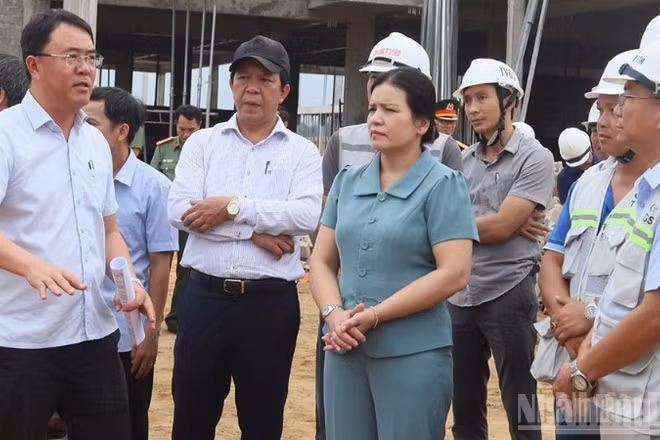 Giám đốc Ban Quản lý dự án đầu tư Tây Quảng Ngãi Võ Đại Tân (đứng bên trái) báo cáo tiến độ triển khai xây dựng trường nội trú liên cấp vùng biên.