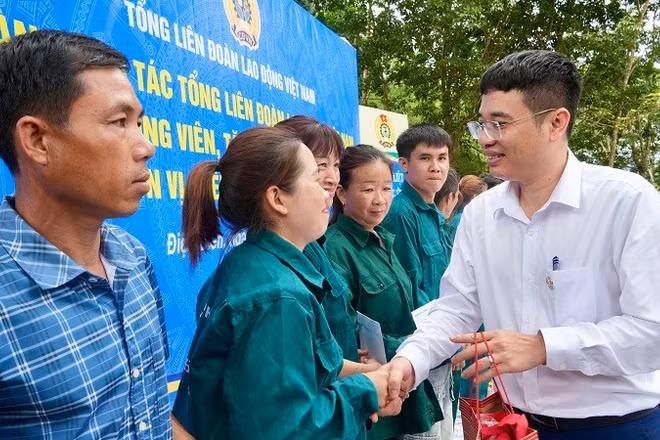 Đồng chí Nguyễn Ngọc Cẩm (áo trắng) Tổng Giám đốc Công ty Cổ phần Cao-su Điện Biên trao quà động viên công nhân, người lao động làm việc trực tiếp tại các vườn cây.