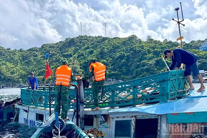 Cán bộ, chiến sĩ Đồn Biên phòng Hòn Chuối hỗ trợ trục vớt tàu cá gặp nạn bị chìm trên biển.