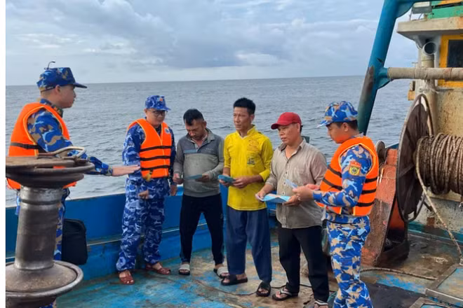 Cán bộ, chiến sĩ Bộ Tư lệnh Vùng Cảnh sát biển 3 phối hợp tuyên truyền về IUU cho ngư dân đang hành nghề trên vùng biển phía nam. Ảnh: MẠNH THẮNG