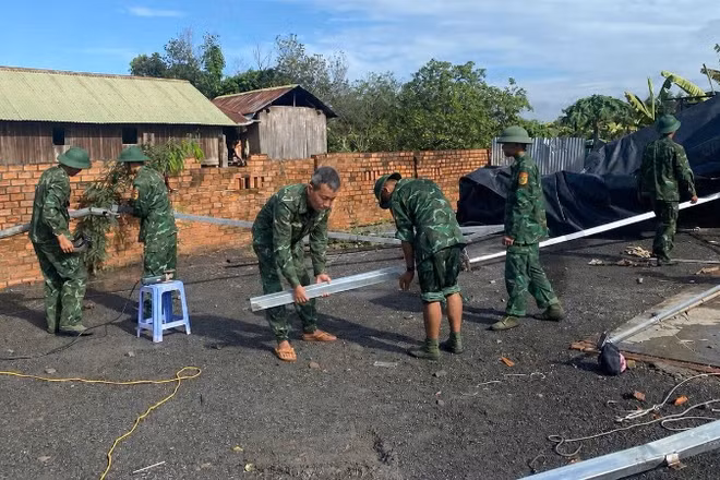 Cán bộ, chiến sĩ Đồn Biên phòng Yok Đôn và Tiểu đoàn Huấn luyện-Cơ động giúp nhân dân xã Buôn Đôn khắc phục hậu quả thiên tai.