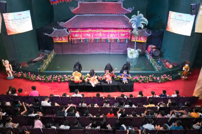 Các cháu chăm chú thưởng thức chương trình biểu diễn của các nghệ sĩ Nhà hát múa rối Bông Sen.