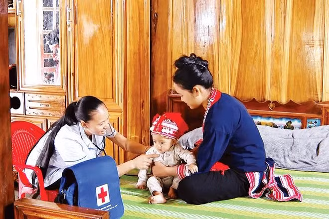 Chị Triệu Thị Ké, y tế thôn Sơn Thành, xã Hồ Thầu đến tận nhà kiểm tra sức khỏe cho trẻ.