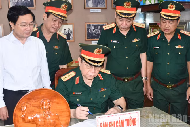 Đại tướng Nguyễn Trọng Nghĩa ghi cảm tưởng tại Nhà truyền thống Cơ quan Chính trị Quân khu 8. (Ảnh: THANH PHONG)