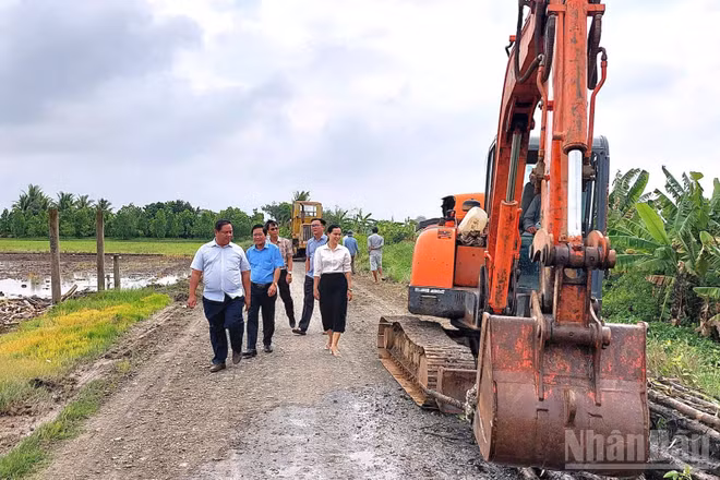 Lãnh đạo xã Tân Trụ trực tiếp kiểm tra tiến độ thi công mở rộng công trình giao thông nông thôn. (Ảnh: THANH PHONG)