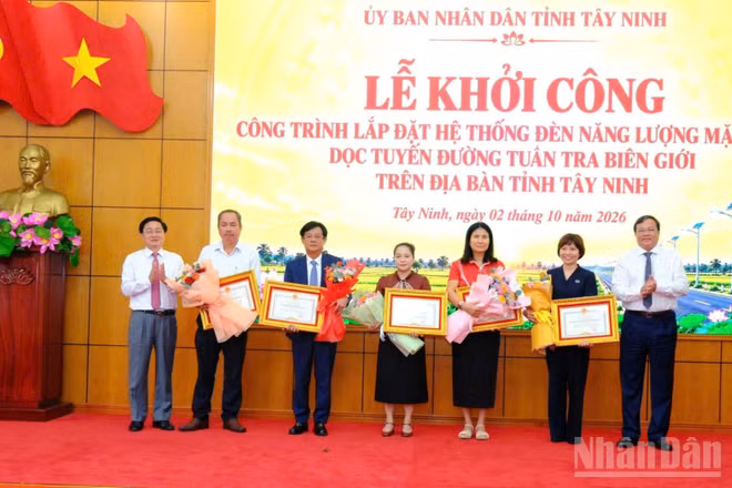 Bí thư Tỉnh ủy Tây Ninh Nguyễn Văn Quyết và Chủ tịch Ủy ban nhân dân tỉnh Lê Văn Hẳn trao hoa và bằng khen của Chủ tịch tỉnh cho 5 nhà tài trợ chương trình “Chung tay thắp sáng biên giới”. (Ảnh: THANH PHONG)
