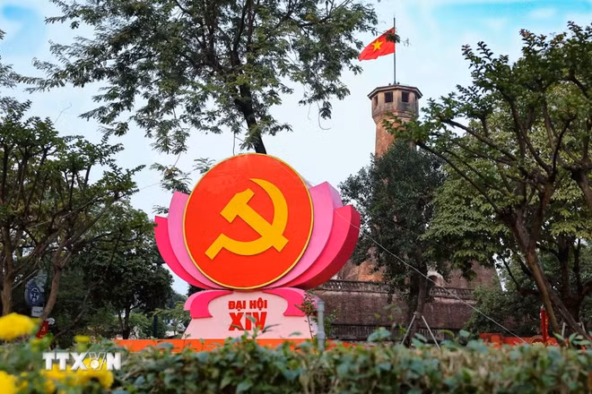 Biểu tượng búa liềm trên đài sen hồng nổi bật trước Cột cờ Hà Nội (khu vực đường Điện Biên Phủ), kết hợp vẻ đẹp lịch sử hào hùng với không khí chính trị trang nghiêm. (Ảnh: Vũ Quang/TTXVN)