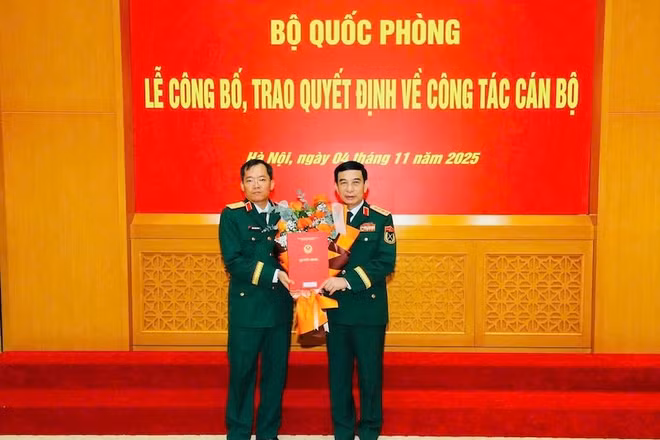 Thừa ủy quyền của Chủ tịch nước, thay mặt Quân ủy Trung ương, Bộ Quốc phòng, Đại tướng Phan Văn Giang trao Quyết định, tặng hoa chúc mừng Thiếu tướng Lương Đình Chung. (Ảnh: Quân khu 5 cung cấp)