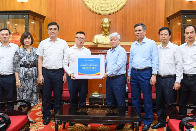 Tổng Biên tập Báo Nhân Dân Lê Quốc Minh trao số tiền quyên góp từ các cán bộ, phóng viên, nhân viên của báo ủng hộ đồng bào khắc phục hậu quả bão, lũ.