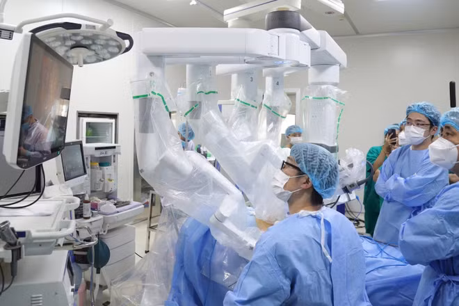 Các bác sĩ Bệnh viện K phối hợp chuyên gia Nhật Bản phẫu thuật bằng robot cho những người bệnh bị ung thư dạ dày, trực tràng, gan và thực quản. (Ảnh MẠNH HÀ)