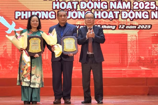 Nhà văn Nguyễn Xuân Tuấn (đứng giữa) và đại diện ủy quyền nhà văn Bành Thanh Bần (ngoài cùng bên trái) được trao giải thưởng Cống hiến sau nhiều đóng góp cho sự phát triển của văn học Thủ đô.