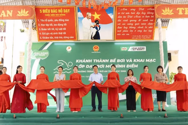 Các đại biểu cắt băng khánh thành bể bơi tại sự kiện.