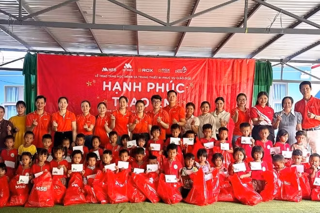 Các em nhỏ nhận quà và học bổng từ chương trình.
