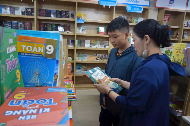 Nhiều gia đình lúng túng tìm mua sách giáo khoa cho con. Ảnh: Bích Huệ
