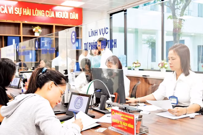 Người dân làm việc với cán bộ tiếp nhận tại bộ phận một cửa phường Đống Đa, Hà Nội. (Ảnh: THẾ ĐẠI)