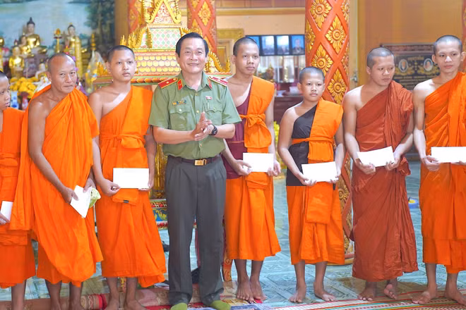 Thiếu tướng Hồ Việt Triều (đứng giữa) thay mặt lãnh đạo tỉnh tặng quà mừng lễ Sene Dolta Ban Quản trị, chức sắc, chức việc Chùa Ngan Dừa, xã Hồng Dân, tỉnh Cà Mau. (Ảnh: HỮU ĐỆ)
