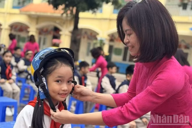 Truyền thông điệp "Mũ bảo hiểm an toàn, Trẻ em an toàn". (Ảnh: HNV)