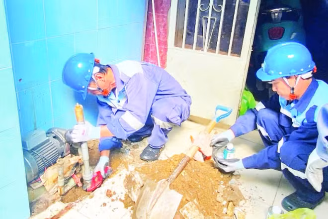 Công nhân Công ty cổ phần cấp nước Gia Định trám, lấp một giếng khoan tại phường Phú Nhuận nhằm hạn chế những tác động tiêu cực do hiện tượng mạch nước ngầm sụt giảm. (Ảnh QUÝ HIỀN)